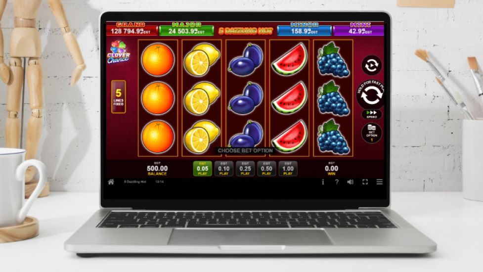 5 Automat do gry Dazzling Hot pokazany na ekranie laptopa, z ikonami owoc&oacute;w i prostą rozgrywką.